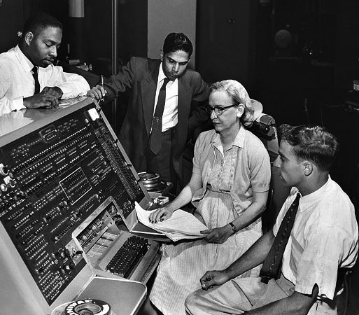 Grace Hopper sitting at UNIVAC computer console with keyboard and control panel, circa 1960